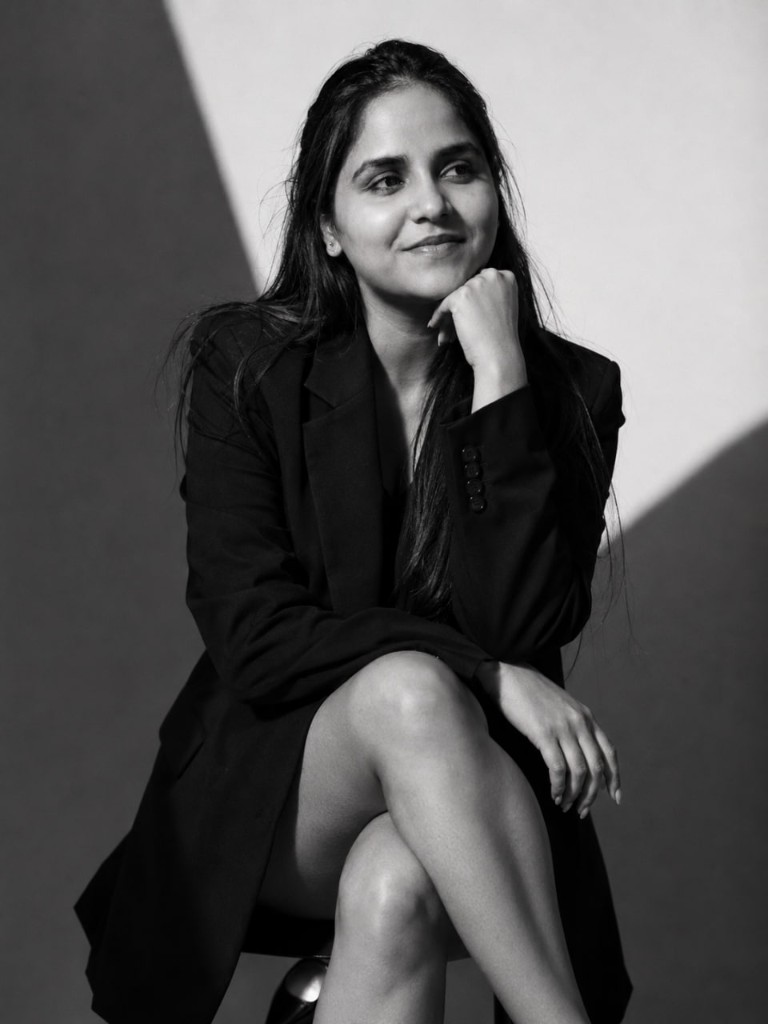 Anamika Rajput seated in a studio, black-and-white portrait